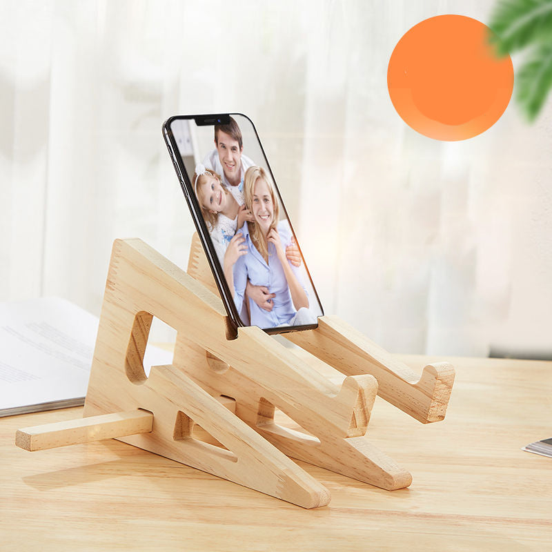 Foldable wooden stand holding a smartphone upright on a desk