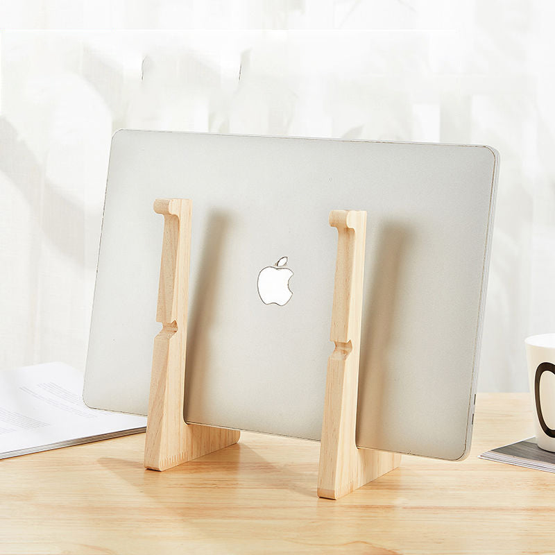 Wooden stand storing a closed laptop vertically on a desk